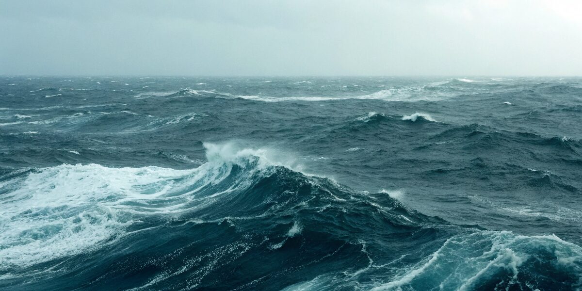 広く深い海の中で襲われる夢を、制御できない感情の波に飲まれそうな心理状態として象徴的に表現したイメージ。